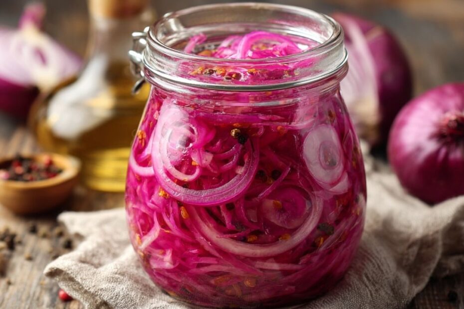 Fein geschnittene rote Zwiebeln eingelegt in Essig im Vorratsglas – farbenfrohes Topping für Bowls & Salate.